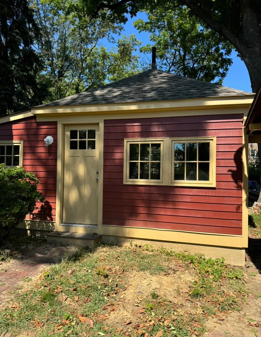 Red board and batten outbuilding with yellow trim