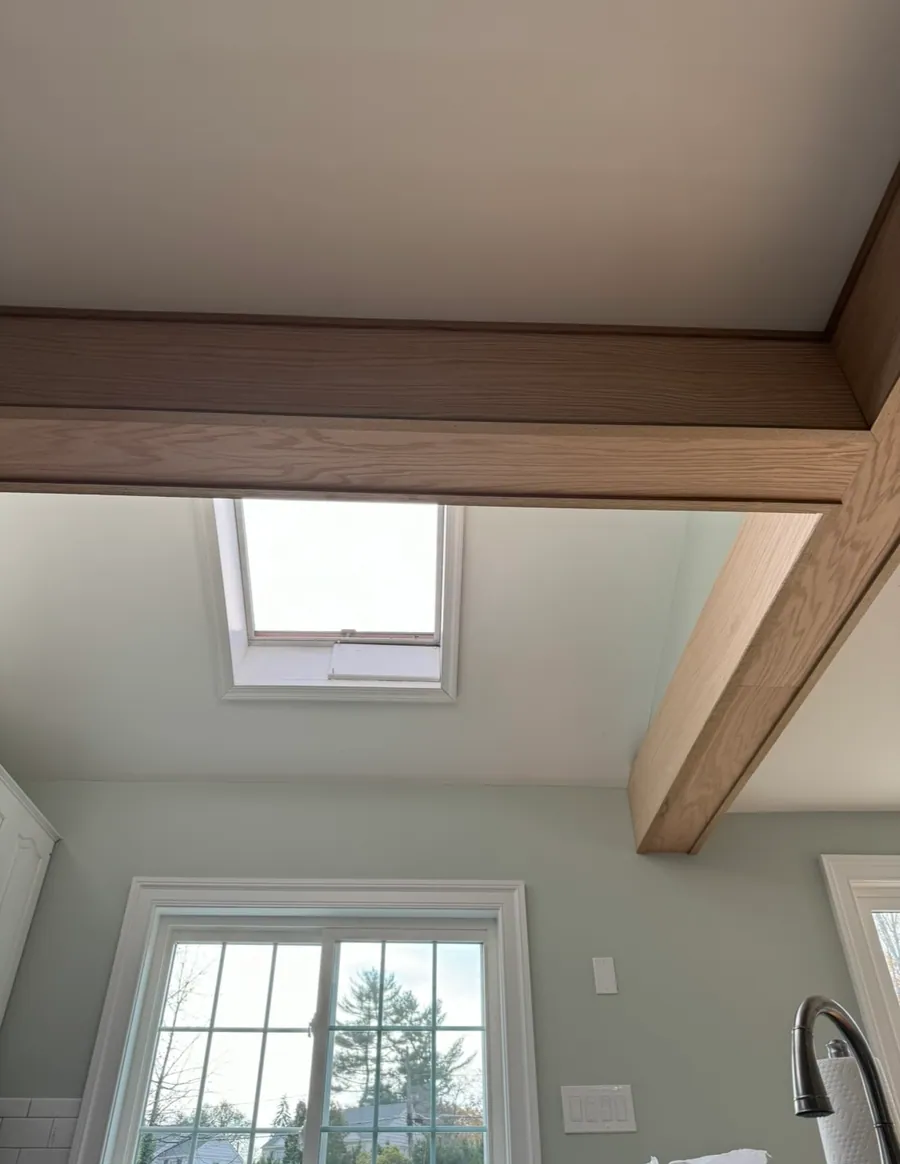 Vaulted ceiling with wood beams and a skylight