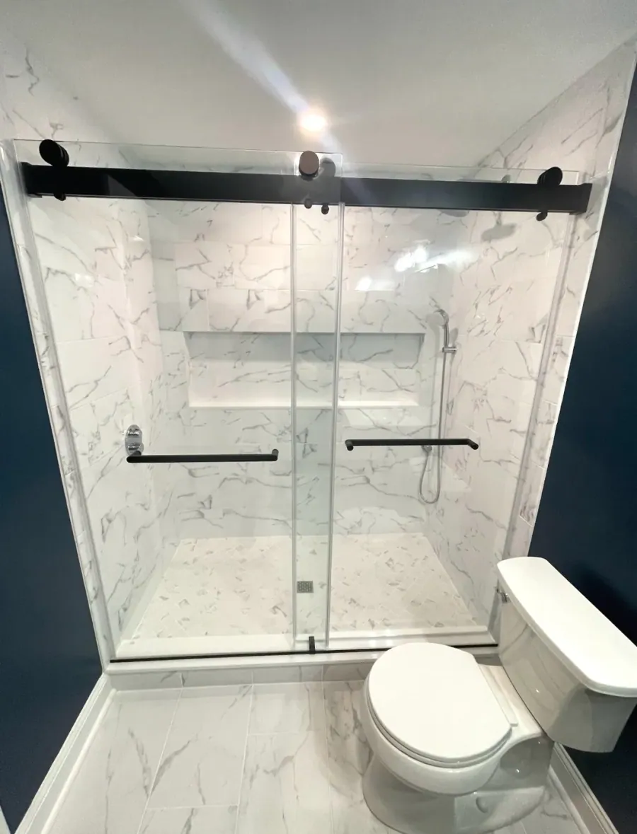 Marble shower with a black framed glass door