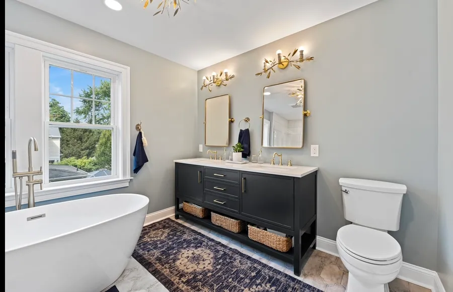 Bathroom with a black double vanity and freestanding tub