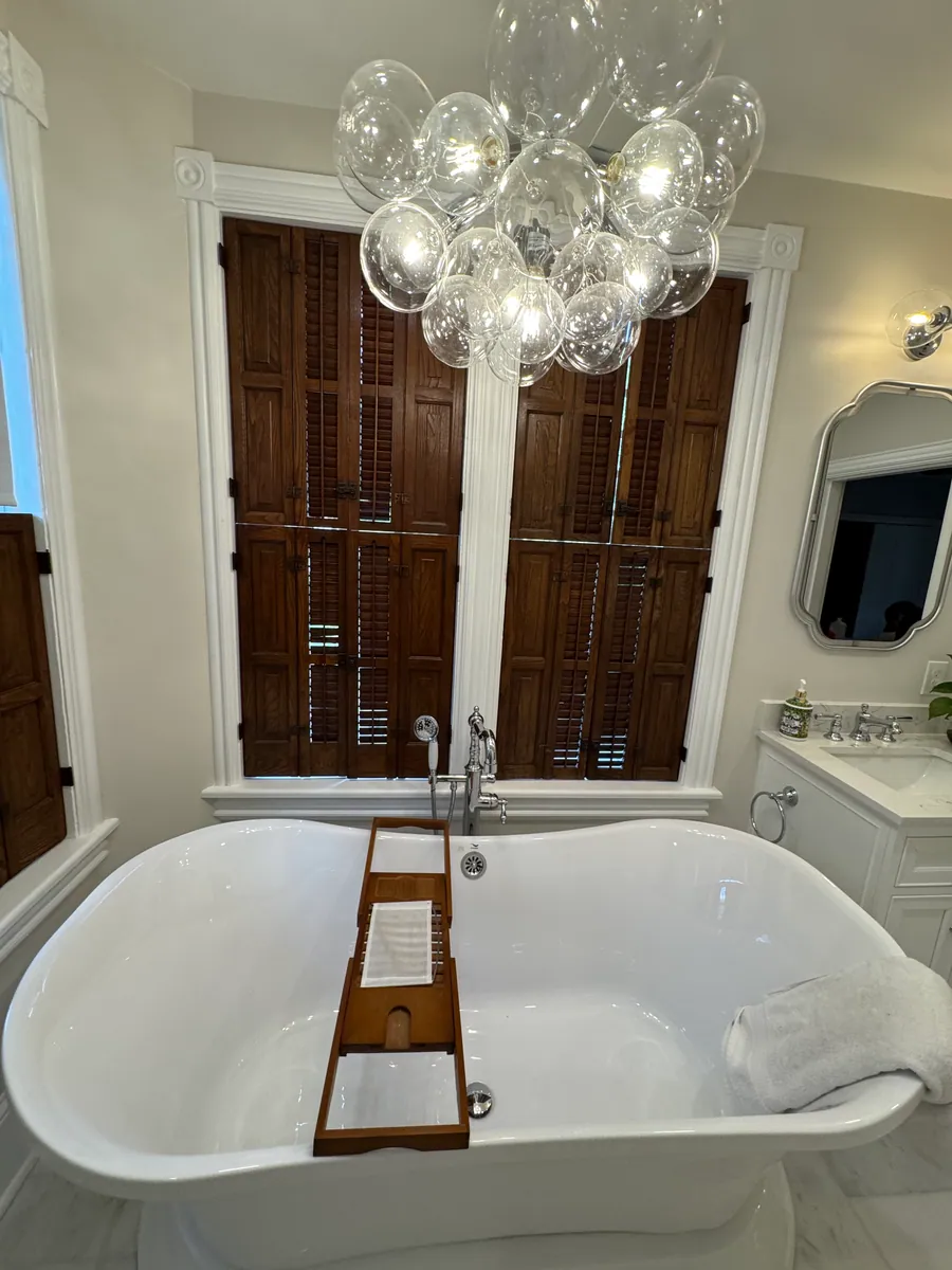 Clawfoot tub under a bubble chandelier