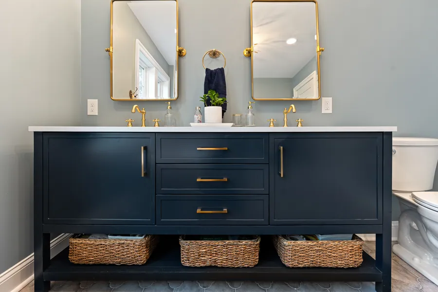 Navy double vanity with brass mirrors and sconces