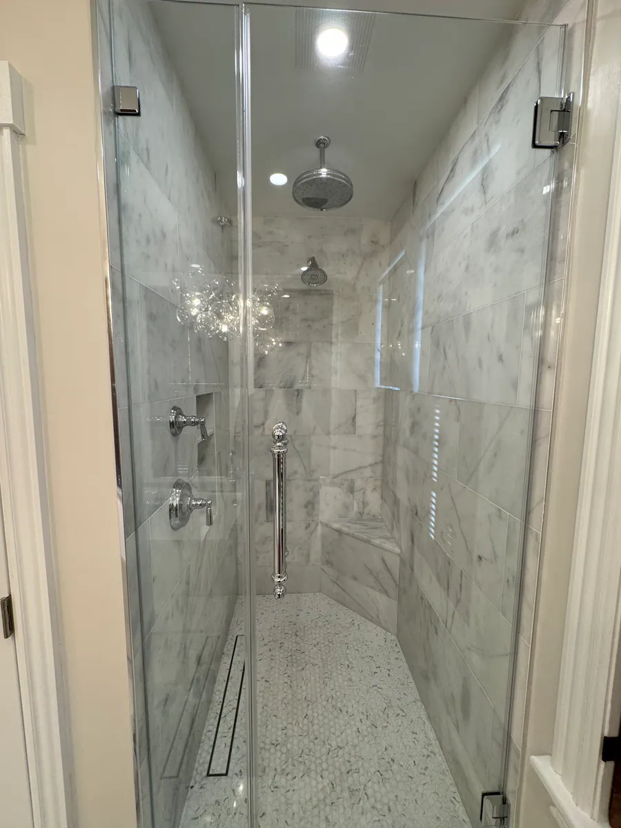 Marble shower behind frameless glass