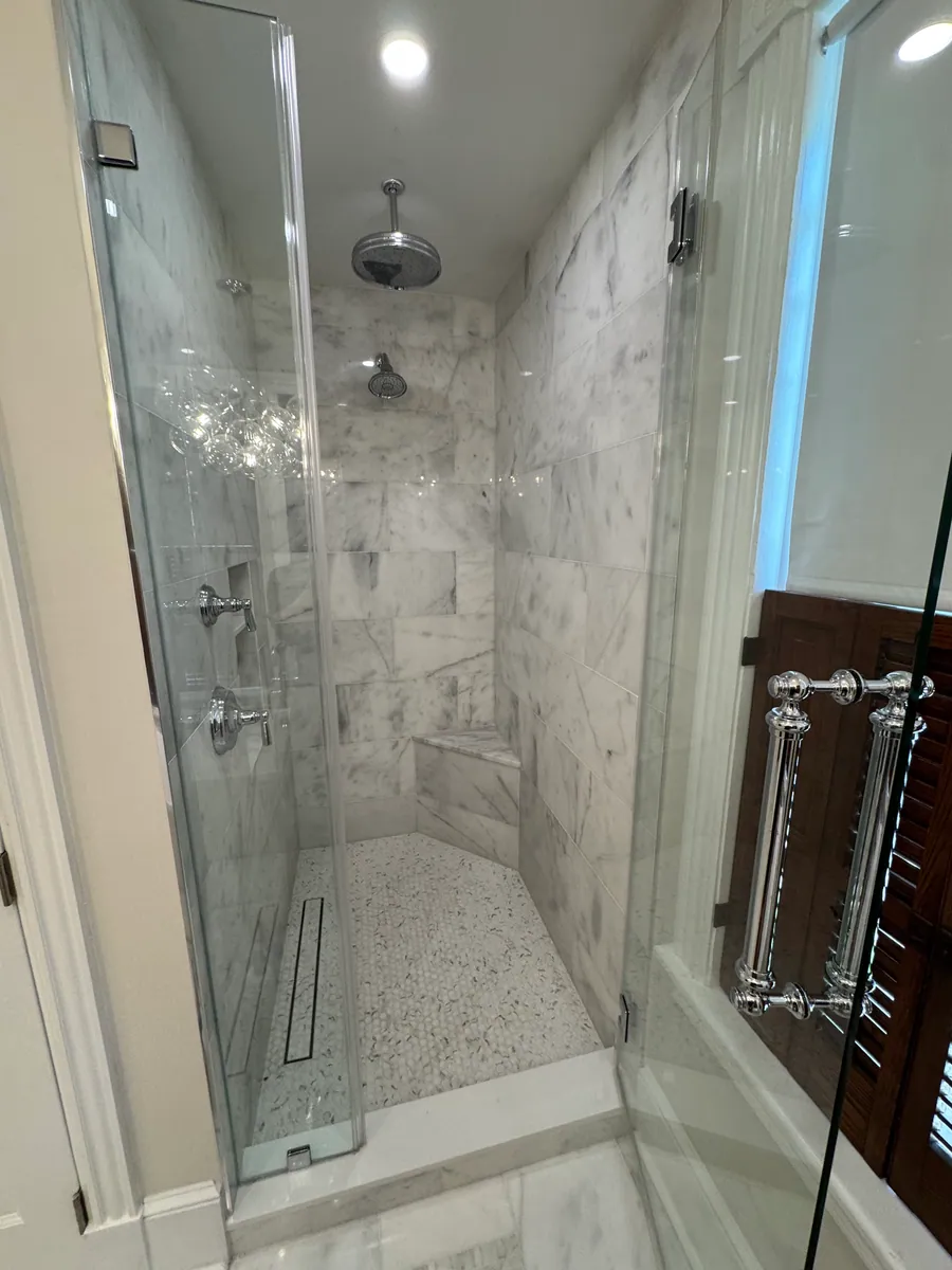 Marble shower with glass panel and linear drain