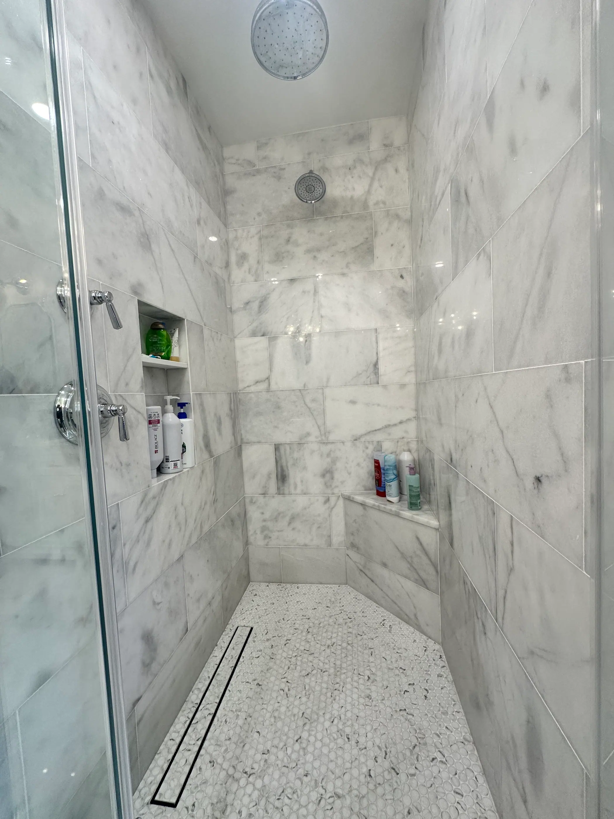 Walk in marble shower with a linear drain