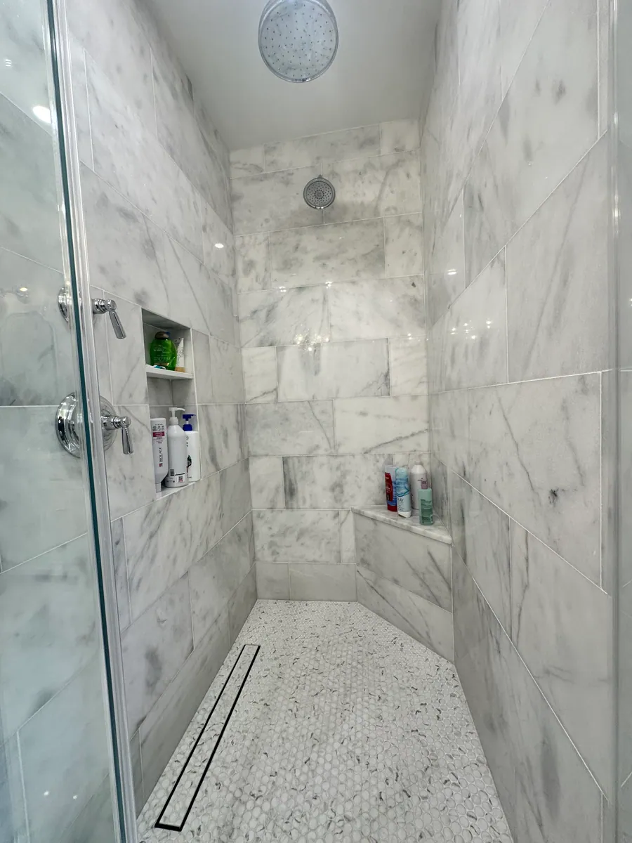 Walk in marble shower with a linear drain