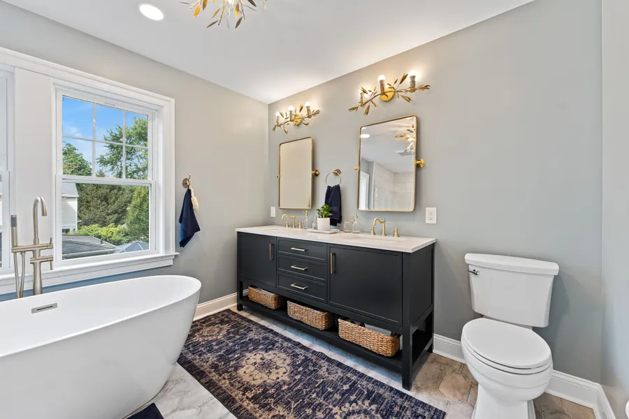 Bathroom with a navy vanity and freestanding tub