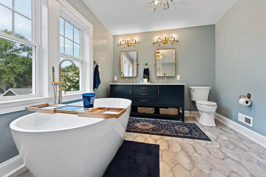Bathroom with a navy vanity, marble top and brass fittings