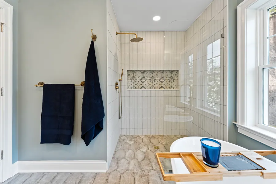 White tile shower with a pebble floor and glass door