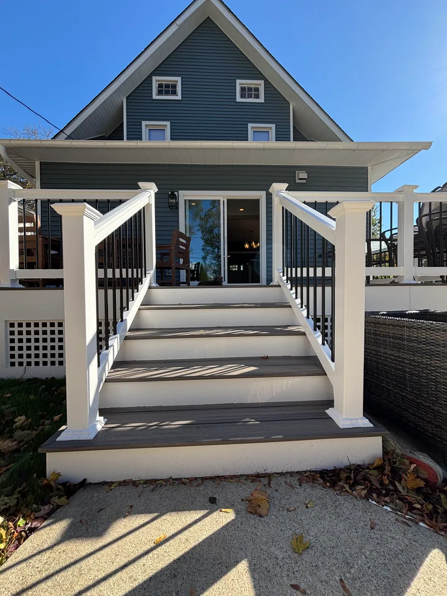 Blue home with a rear deck and stairs