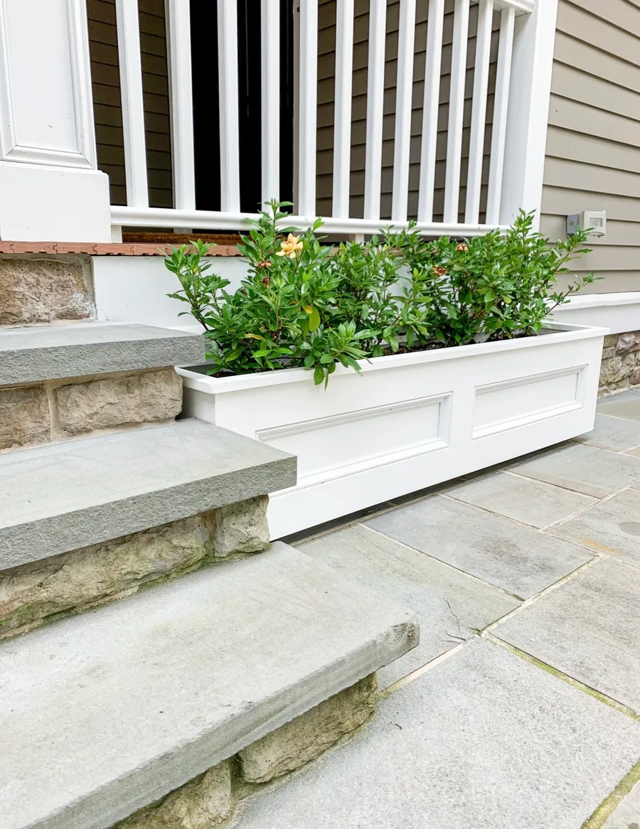 White window box beside stone entry steps