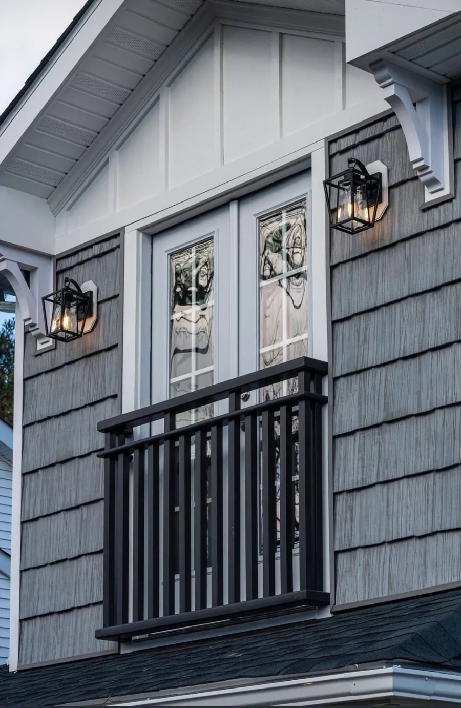 Shingle gable with a balcony and carriage lights