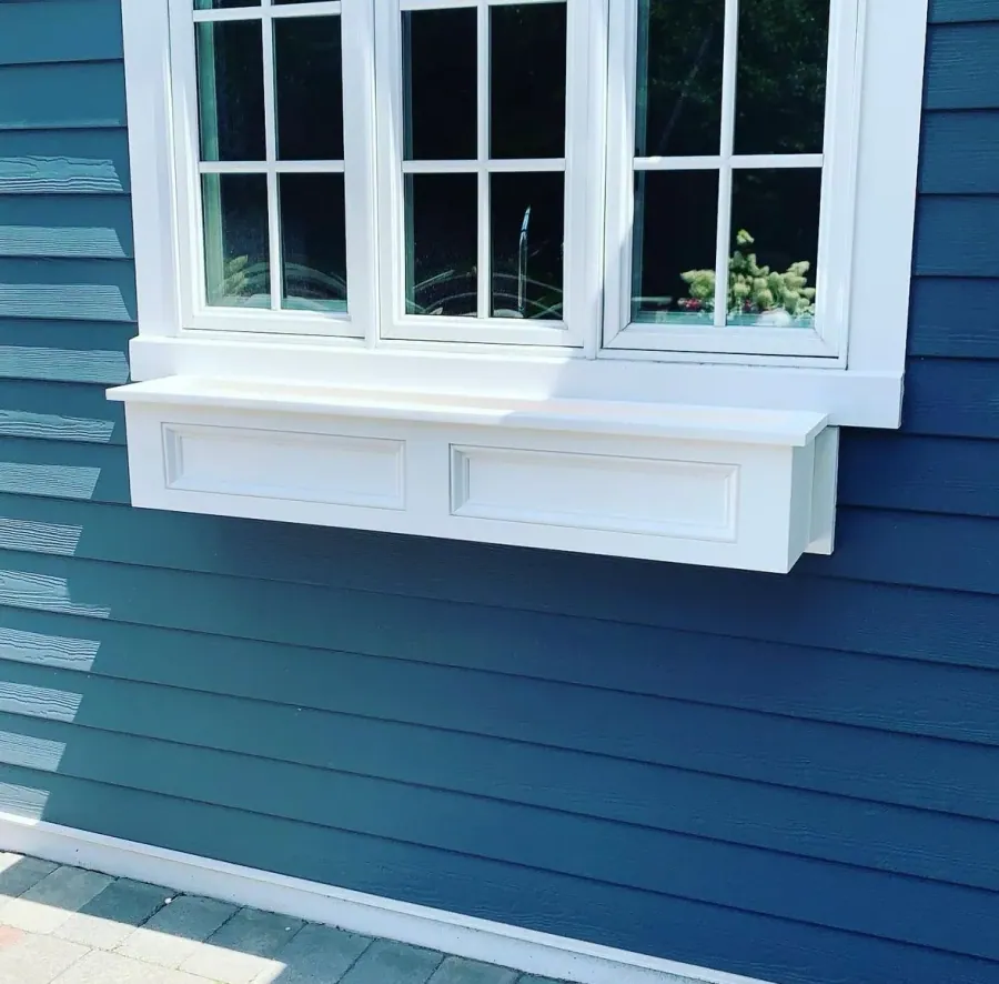 White window trim against navy lap siding