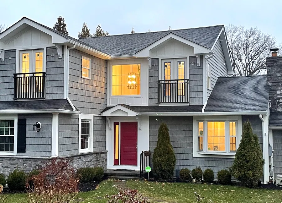 Cedar shingle home at dusk with lit windows