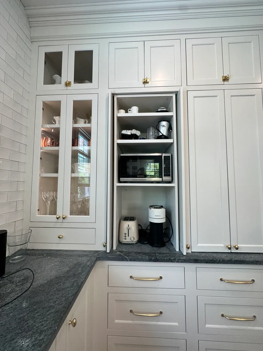 White kitchen with glass front uppers and soapstone counters