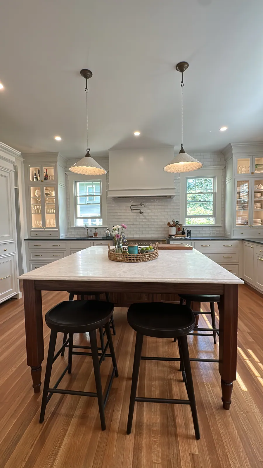 Kitchen with a furniture style island table and counter stools