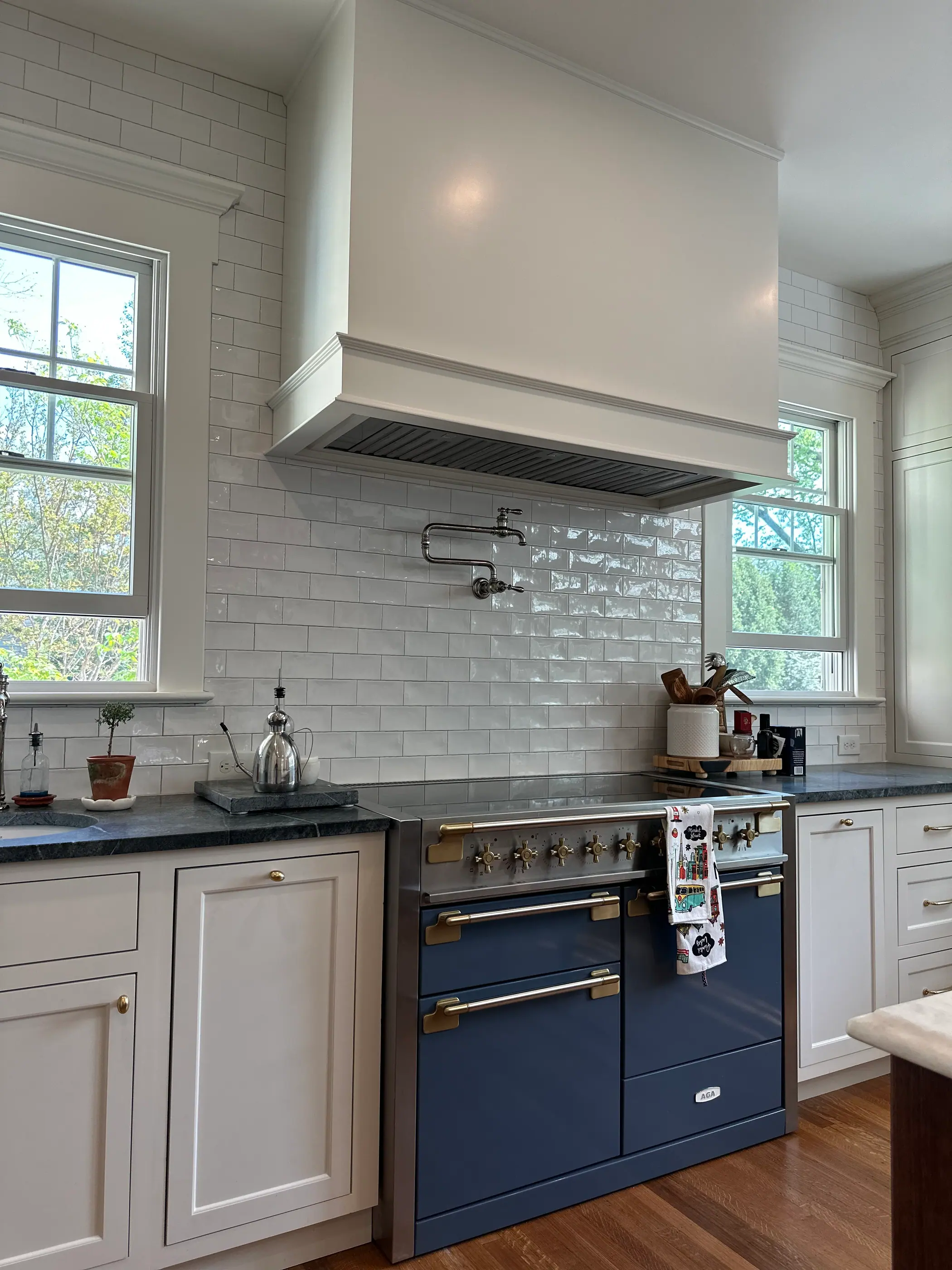 Navy range set into white cabinetry with soapstone counters