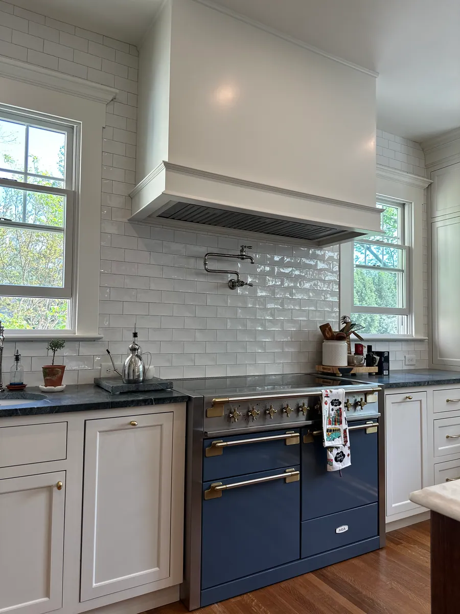 Navy range set into white cabinetry with soapstone counters