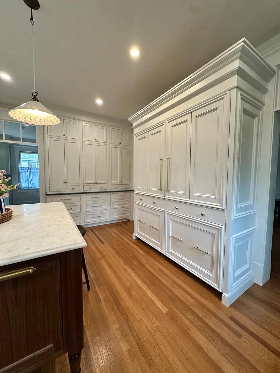 Panelled white kitchen with tall cabinetry and a marble island