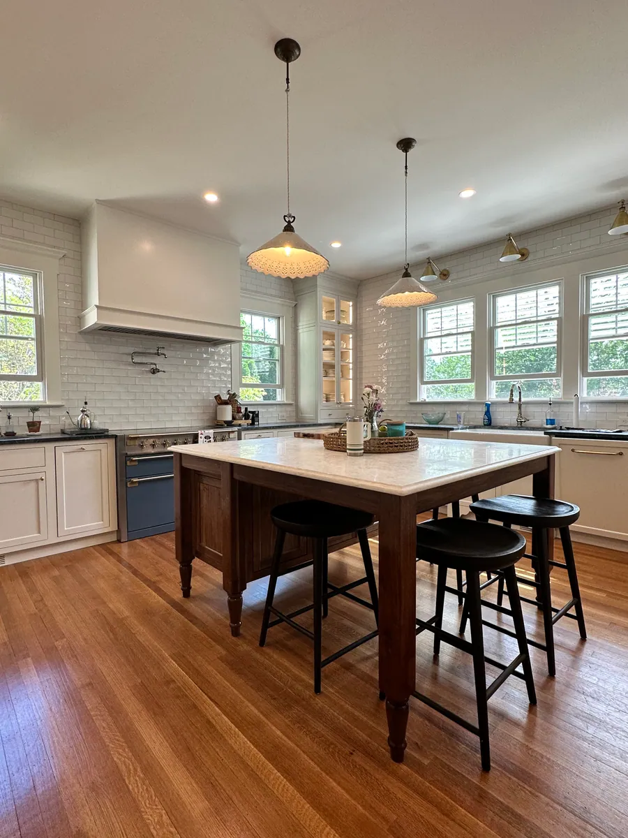 Open kitchen with an island table and glass pendants