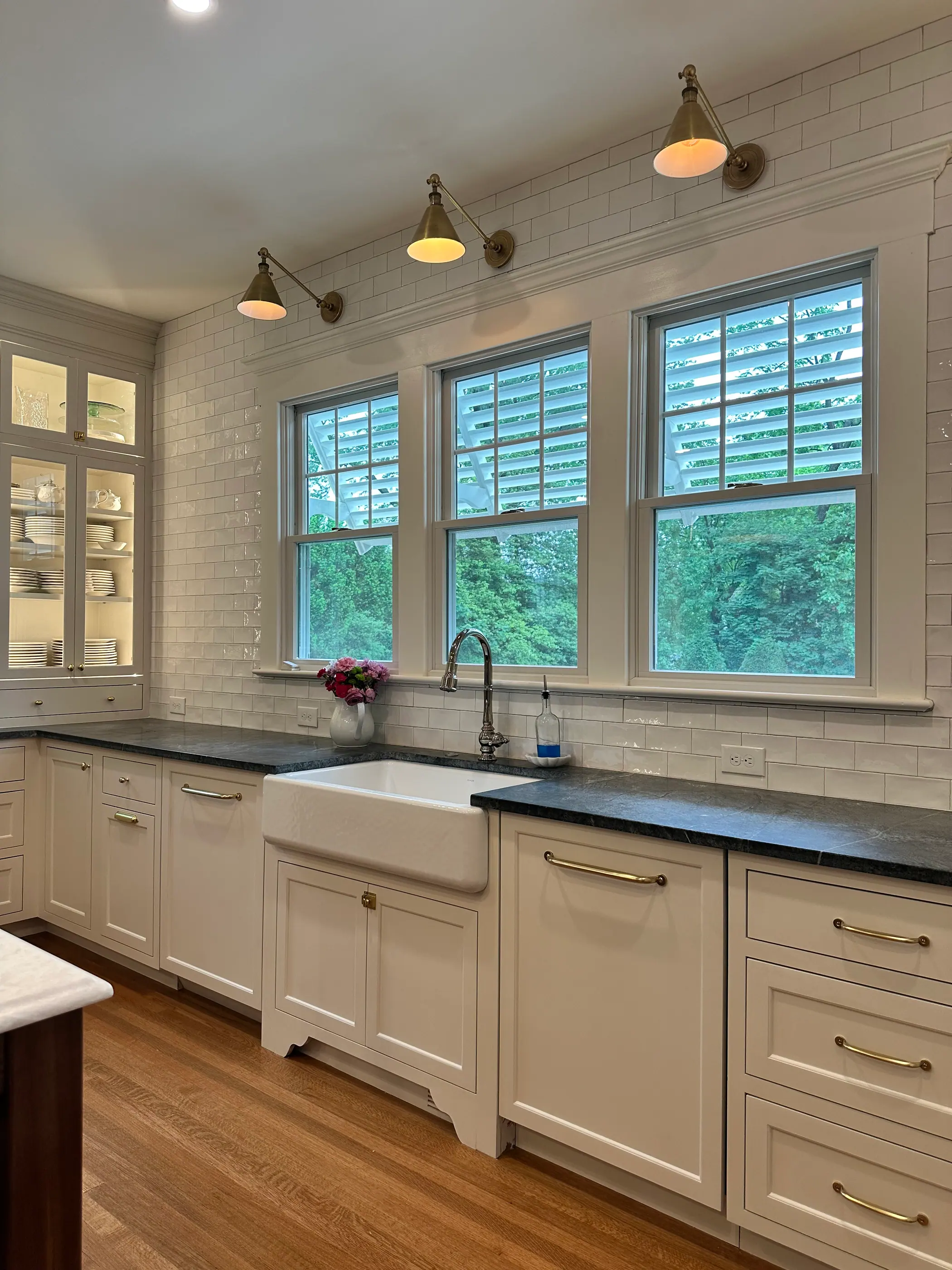White kitchen with soapstone counters and pendant lights over the sink