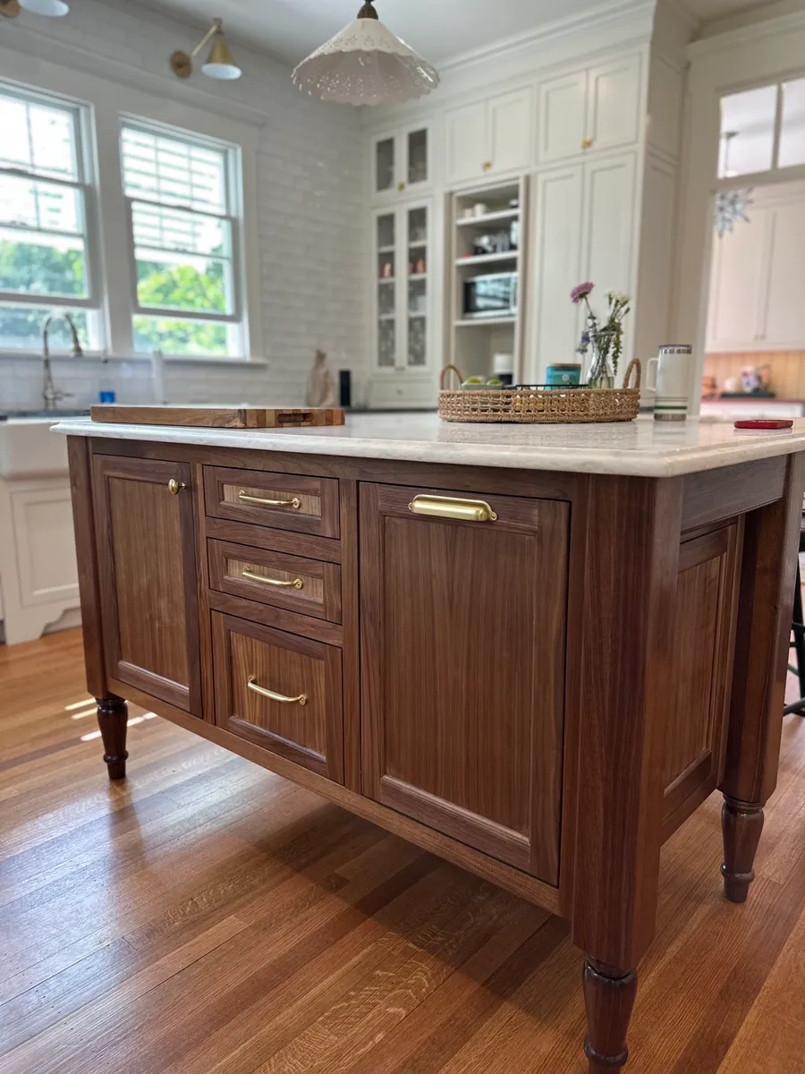 White kitchen with a turned leg walnut island