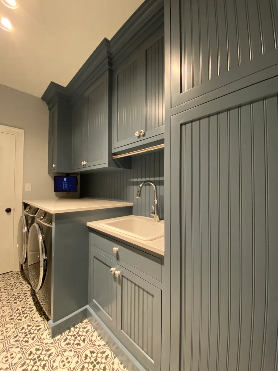 Laundry room with beadboard cabinetry and a folding counter