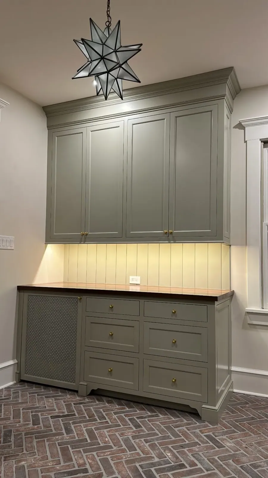 Grey mudroom lockers over a brick herringbone floor