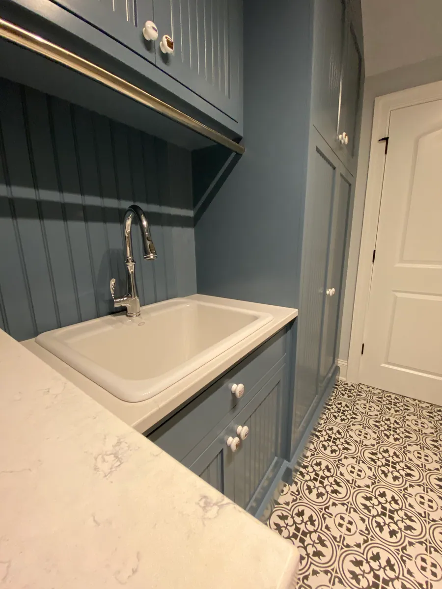 Laundry sink set into painted cabinetry