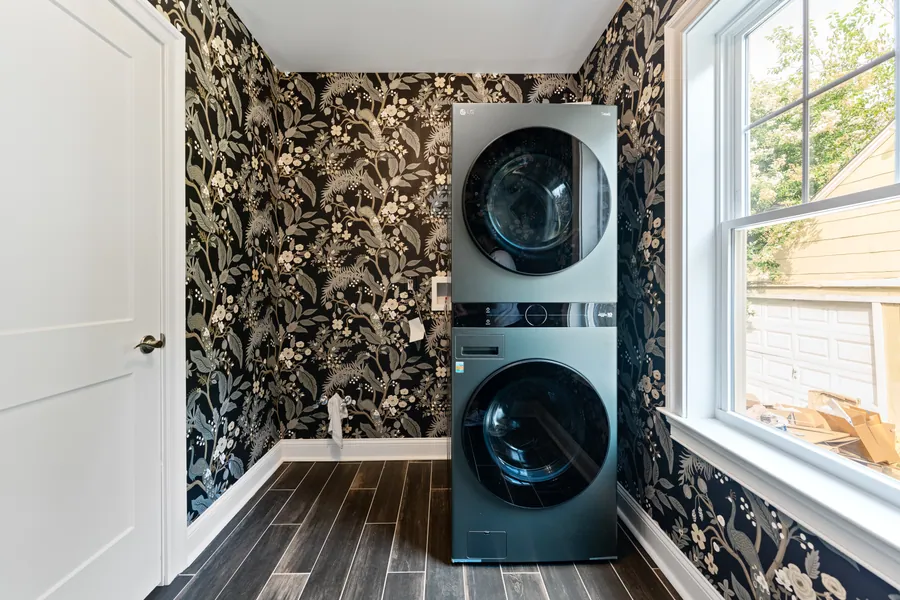 Laundry with a stacked washer and dryer set into cabinetry
