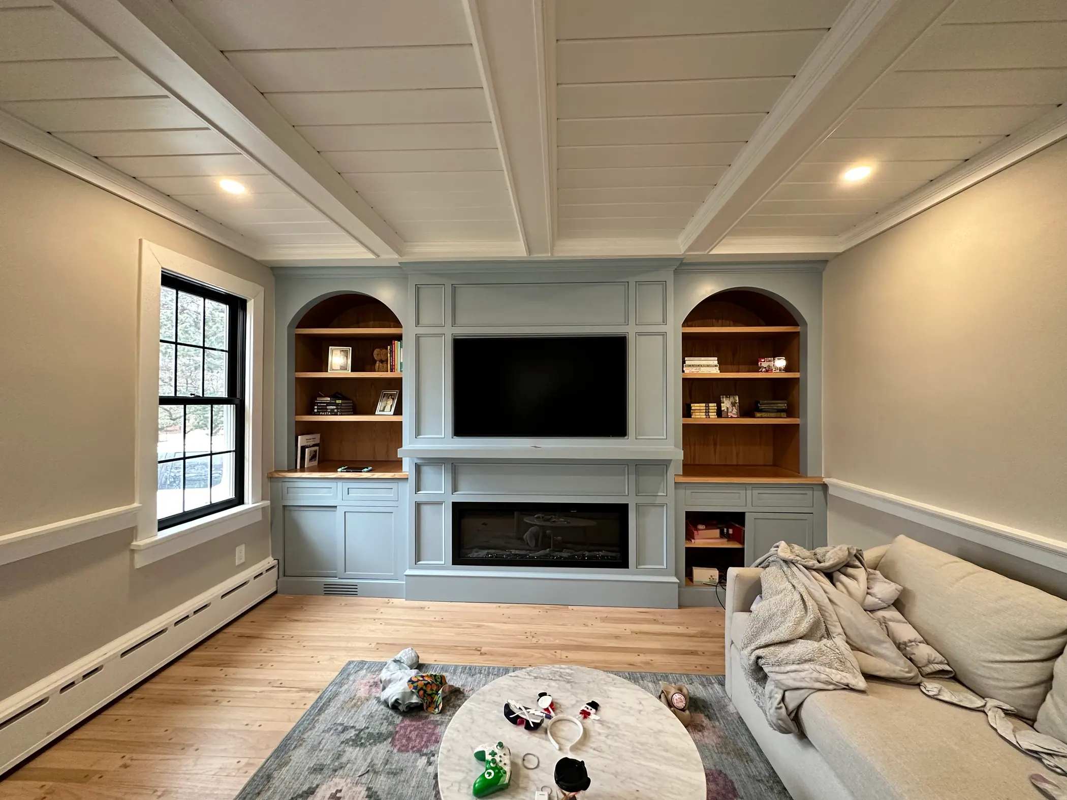 Living room built ins with arched niches and a shiplap ceiling