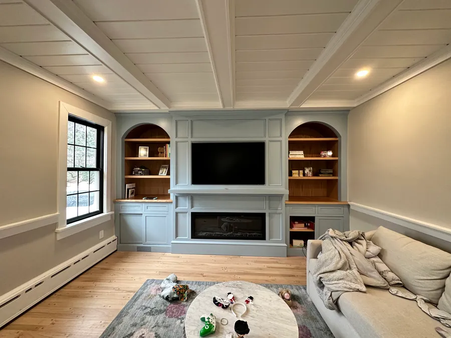 Living room built ins with arched niches and a shiplap ceiling