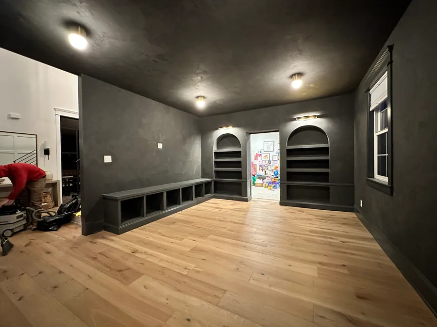 Dark plaster den with arched niches and a window bench