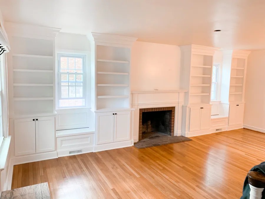 Fireplace flanked by built in cabinets and shelves