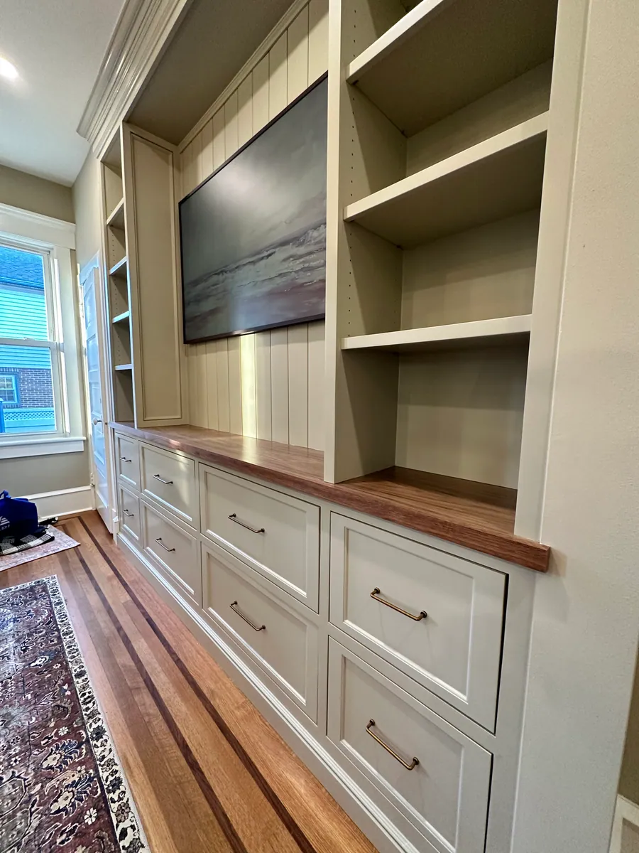 Built in media wall with a walnut counter and drawers