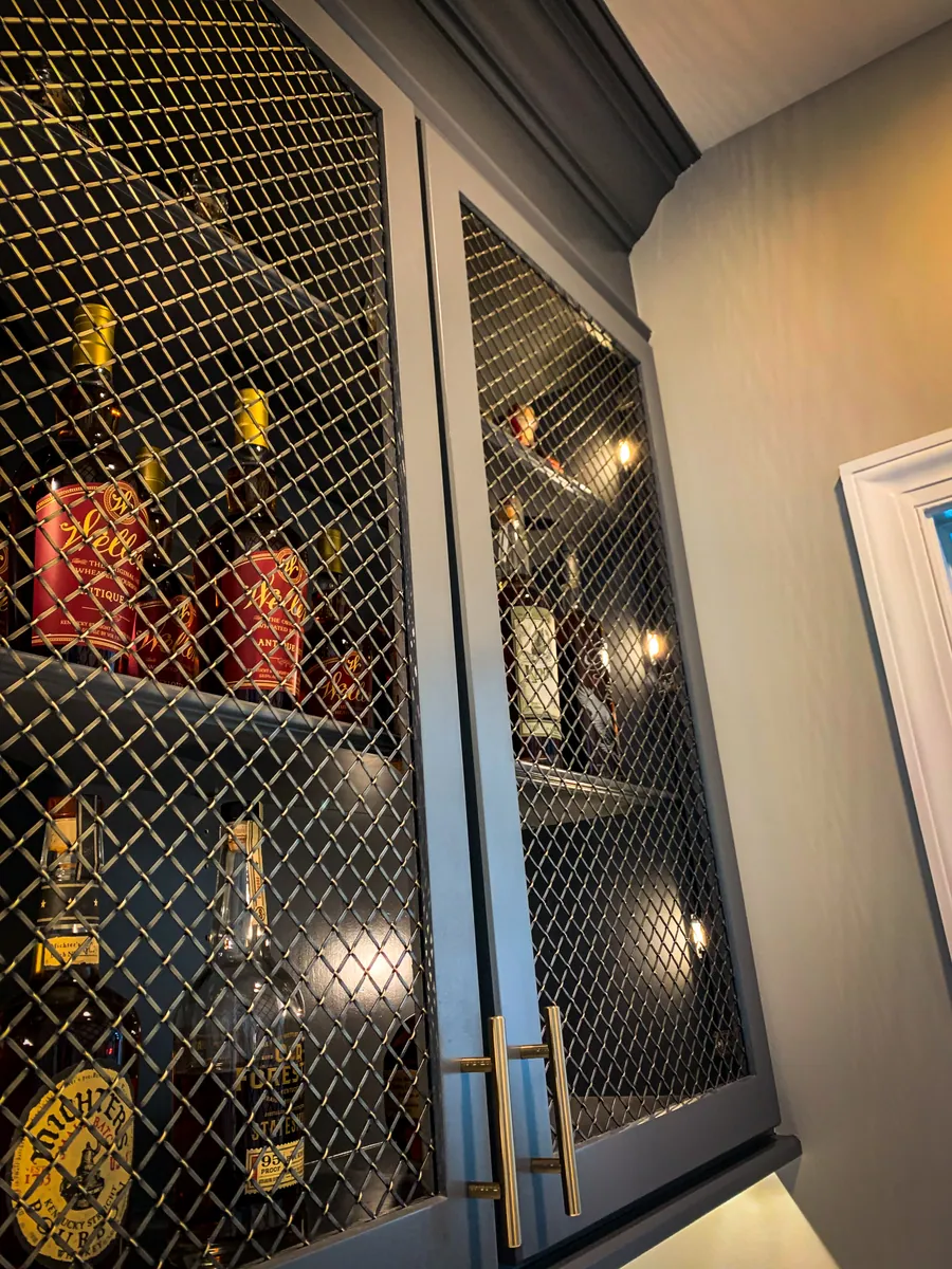Bar cabinet with mesh door fronts and interior lighting