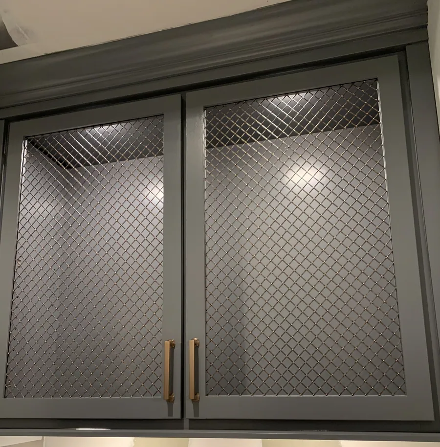 Mesh cabinet door detail with brass pulls