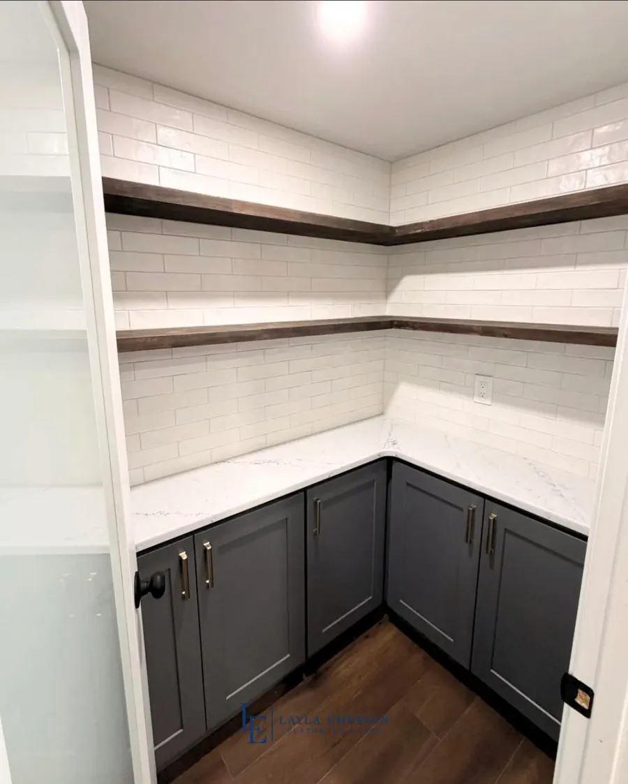 Pantry with painted cabinetry and wood shelves