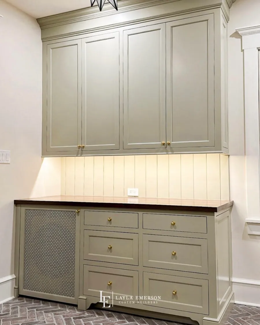 Sage cabinetry with a wood top and radiator cover