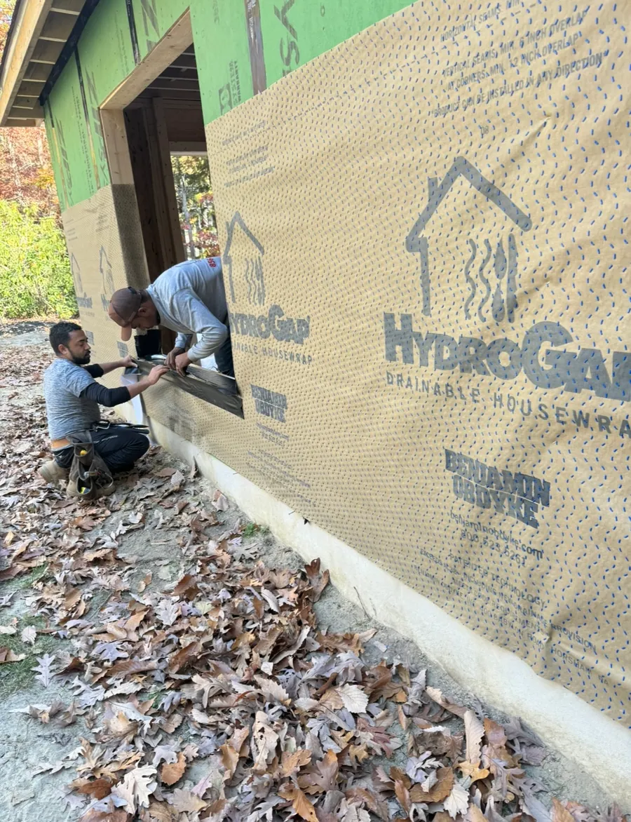 Crew fitting house wrap to a new build