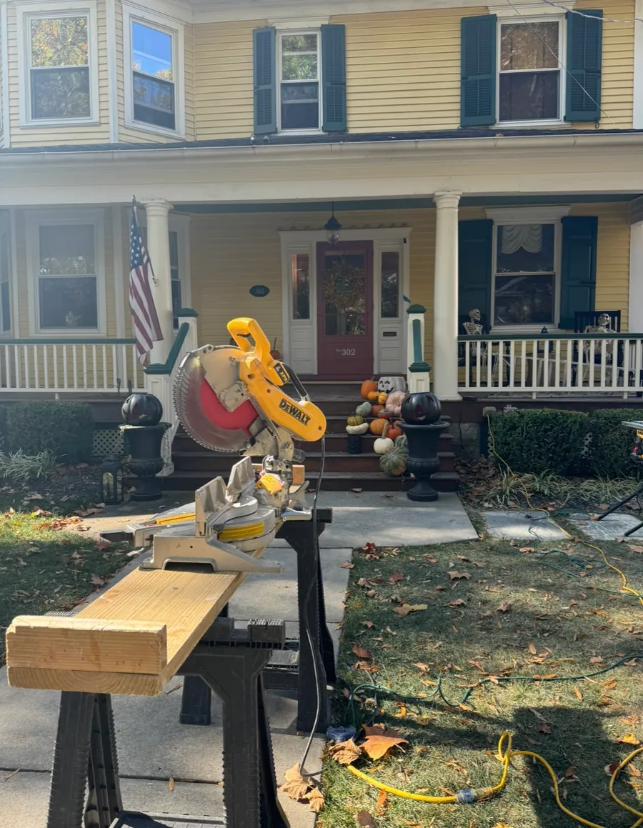 Trim being cut on sawhorses at the front porch